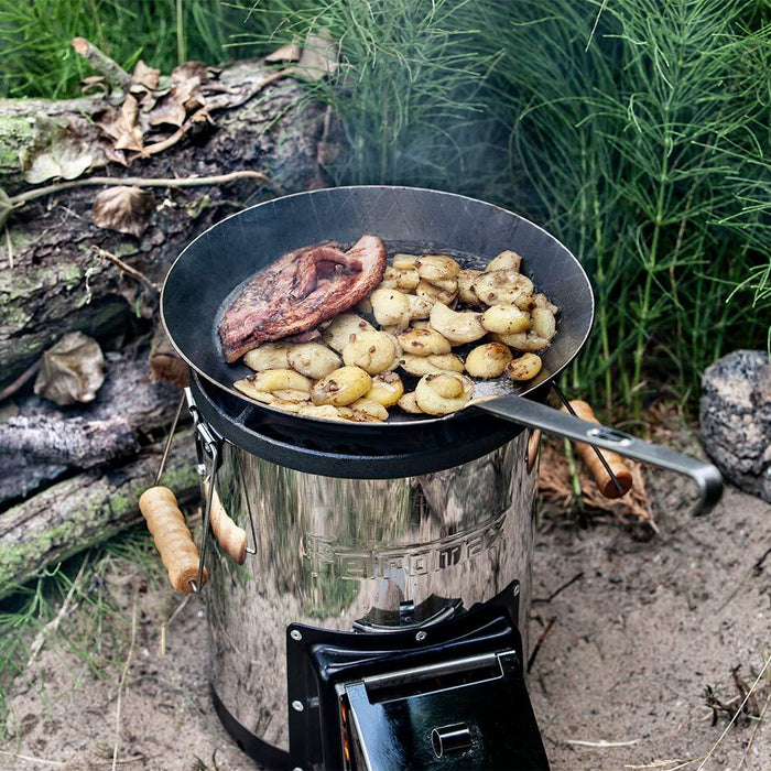Bratkartoffeln in einer Schmiedeeisernen Pfanne über einem Raketenofen