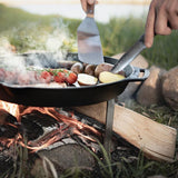 Person rührt Essen mit Pfannenwender in der Pfanne