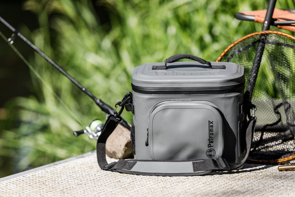 Graue Petromax Kühltasche liegt am See